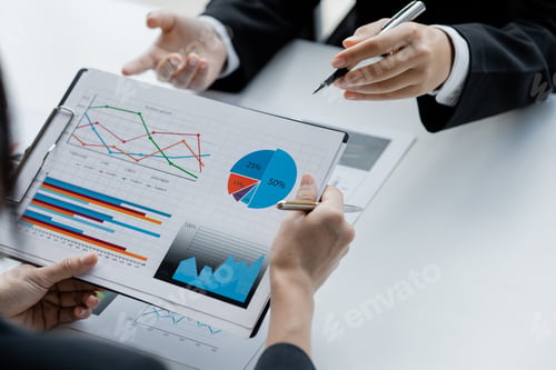 Preview: Two businessmen are reviewing monthly sales documents for analysis.