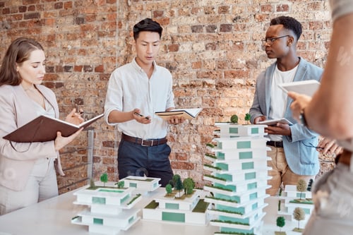 Preview: Group of diverse architects discussing plans, blueprints and schematics during a meeting in their o