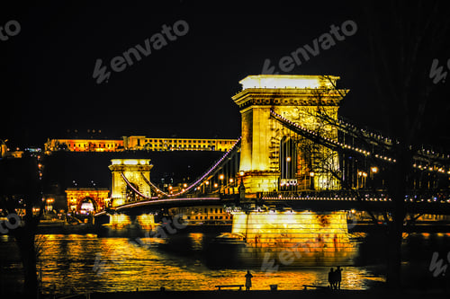 Preview: Beautiful view of illuminated Budapest bridge at night with reflections on the Danube river surface