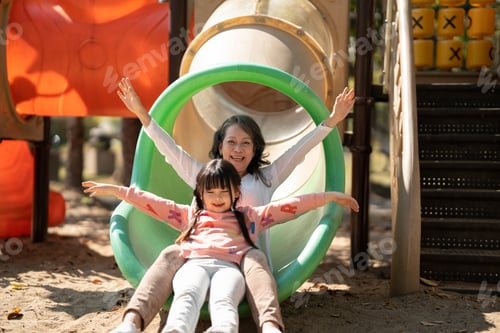 Preview: Little girl and her grandmother having fun at outdoor playground in the park