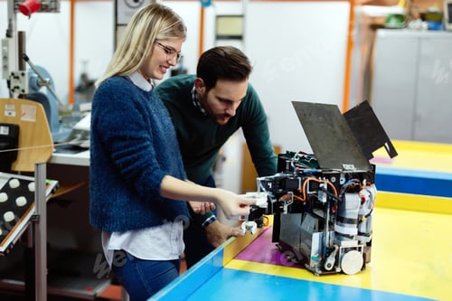 Preview: Young students of robotics preparing robot for testing