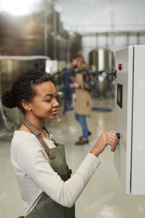 Preview: Young African American Woman Pushing Buttons at Factory