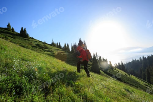 Preview: Woman backpacker hiking on beautiful mountain peak