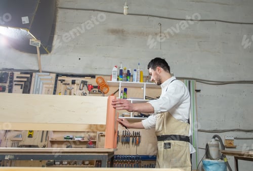 Preview: Small-Sized Companies, furniture and worker concept - Handsome young man working in the furniture