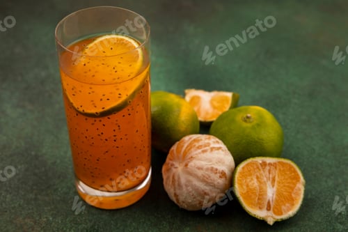 Preview: top view of juicy and healthy tangerines with fresh fruit juice on a glass on a green background