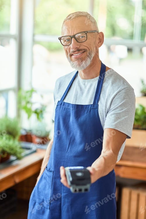 Preview: Middle aged caucasian man holding bank terminal