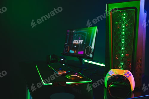 Preview: Composite of computer with video game accessories with copy space on neon background