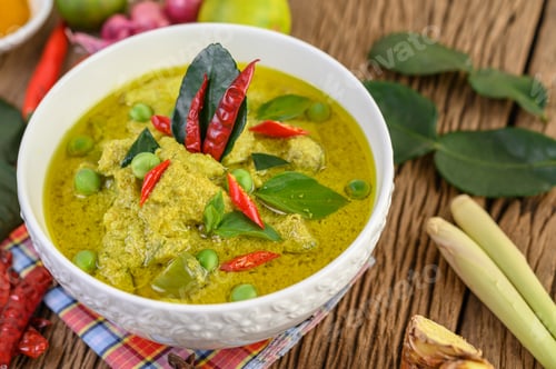 Preview: Green curry in a bowl with lime, red onion, lemon grass, garlic and kaffir lime leaves