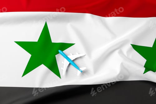 Preview: Small toy plane over the fabric flag of Syria