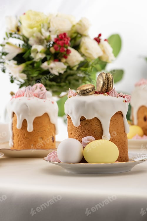 Preview: Delicious Easter Cake With Golden French Macaroons And Meringue on Icing Near Floral Bouquet, Eggs