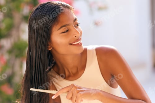 Preview: Woman Brushing Shiny Long Hair Outside in Sunlight