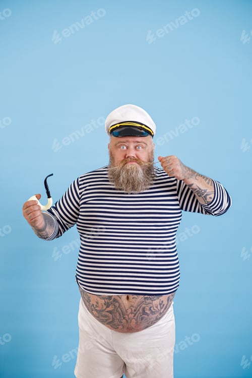 Preview: Bearded obese man sailor with smoking pipe tightens up mustache on light blue background