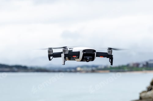 Preview: Modern drone flying over rocky seacoast
