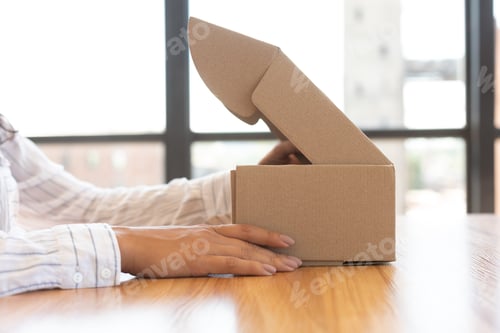 Preview: Woman opening box with new parcel, close-up