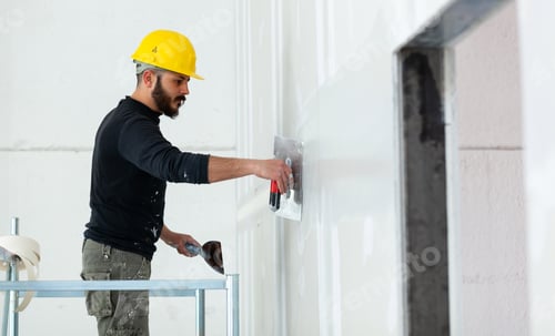 Preview: worker plastering gypsum board wall.