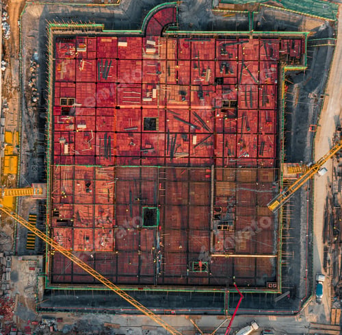 Preview: Aerial view of a construction site featuring a large amount of red bricks stacked atop one another