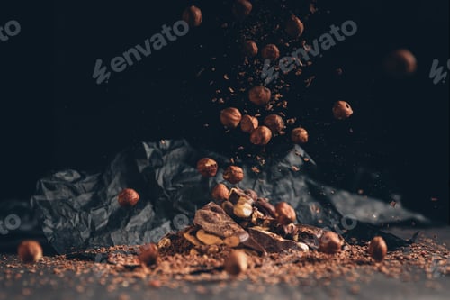 Preview: Falling nuts on pile of chocolate on a table