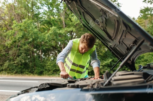Preview: Man in reflective vest at opened hood, breakdown