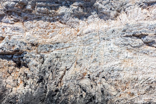 Preview: Grey rock background texture. Stone formation, rough natural material shaped by the sea, salt wind