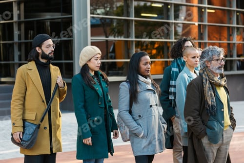 Preview: Group of serious businessmen and women standing looking forward