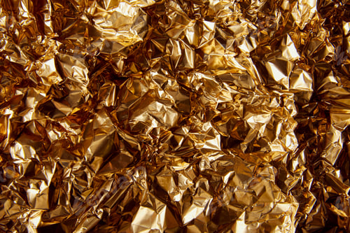Preview: top view of crumpled golden foil with glares