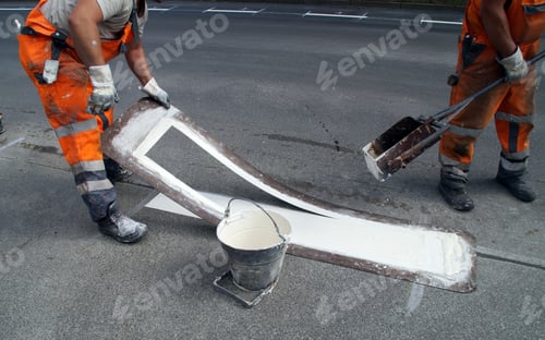 Preview: Closeup shot of a worker printing street lines for driving on the ground