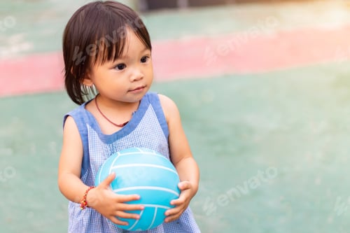 Preview: Asian baby child girl playing ball toys at the field playground.