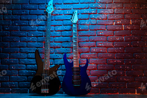 Preview: Electric guitar in neon light against dark walll