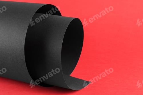 Preview: Black rolled sheet of paper on a red background