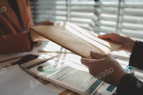Preview: working atmosphere in an office during the day, an employee is sitting at his desk working with his