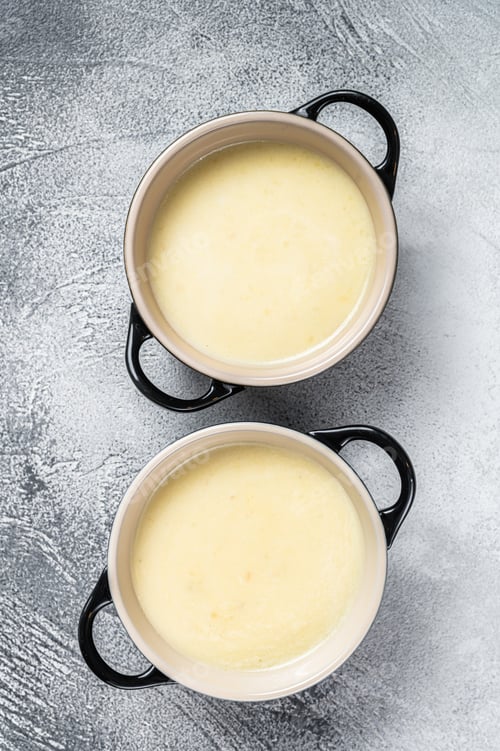 Preview: Homemade potato cream soup in bowls. White background. Top view