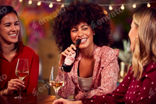 Preview: Multi-Cultural Group Of Female Friends Enjoying Party Night Out In Bar Drinking Beer And Wine