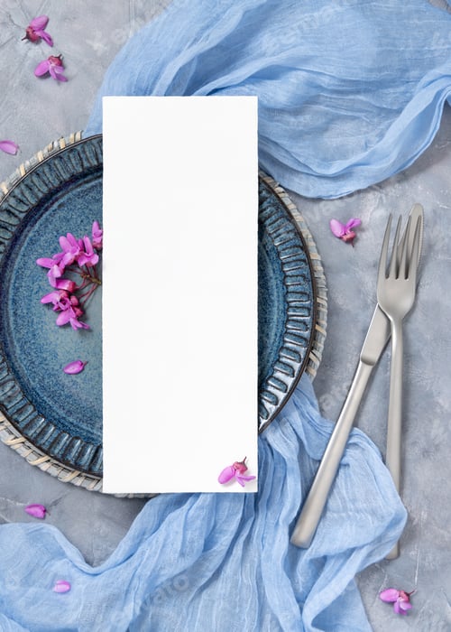 Preview: Wedding table place with a card near fabric and wild purple flowers top view on gray, spring mockup