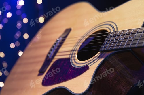 Preview: Close-up, acoustic guitar on a dark background with bokeh lights.