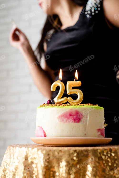 Preview: caucasian woman in black party dress lighting candles on birthday cake