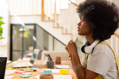 Preview: African American woman sitting at table in office, arranging colorful sticky notes, copy space