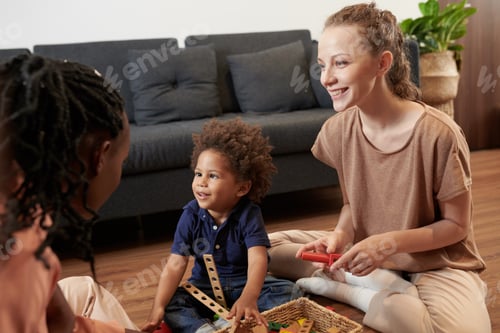 Preview: Cheerful toddler boy enjoying playing with parents at home