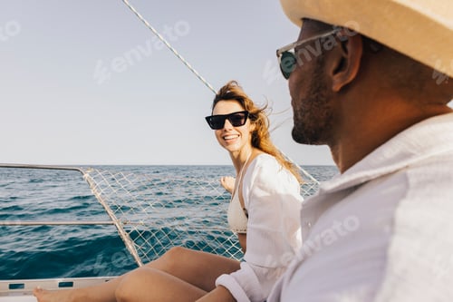 Preview: Smiling young couple enjoying a sunny day on a sailboat