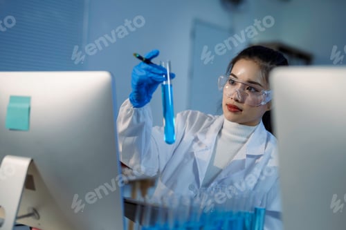 Preview: Scientist analyzing blue liquid in test tube in laboratory