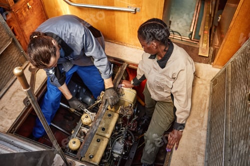 Preview: Top view two people repairing boat engine in pit