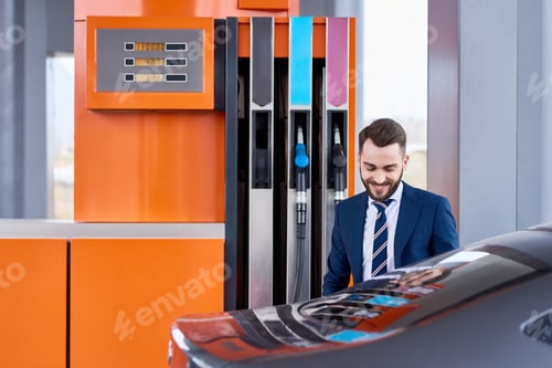 Preview: Smiling Successful Businessman Refueling Gas Tank