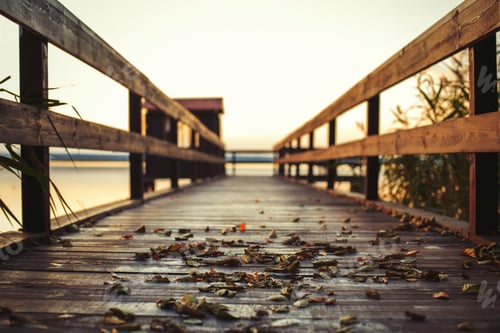 Preview: sunset on a wooden pier. Autumn landscape with falling leaves