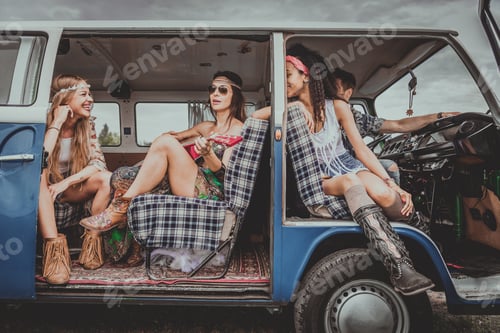 Preview: Happy friends driving a vintage minivan