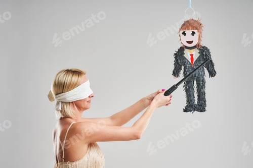 Preview: Woman hitting male pinata over grey background