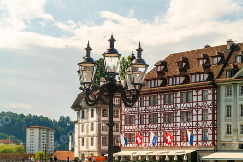 Preview: Historic European buildings under a clear blue sky with ornate street lamps in the foreground
