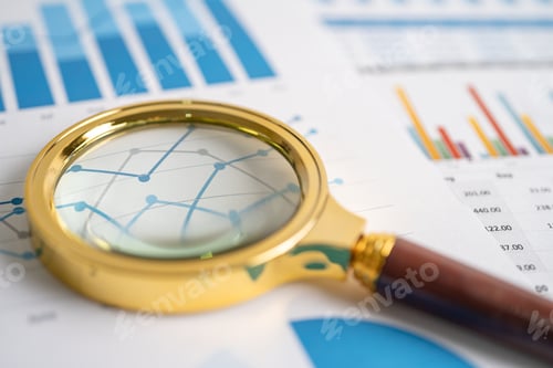 Preview: Magnifying glass on charts graphs paper.