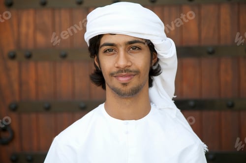 Preview: Young man smiling in traditional attire against a textured background