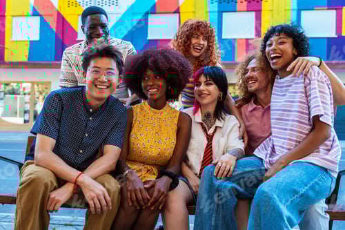 Preview: Multiethnic group of young friends meeting and having fun outdoors