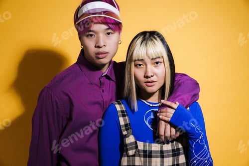 Preview: Asian couple with multicolored hair hugging while posing together