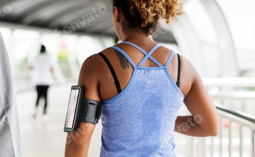 Preview: Healthy woman exercising while using technology